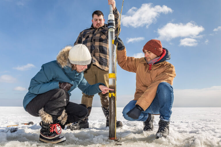 Participants in an eelgrass coring workshop gather sediment cores from an eelgrass meadow, which will be used to establish how long the carbon stored by eelgrass stays locked away.