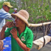 Trapang Ropov community members load a concrete pillar onto a raft.