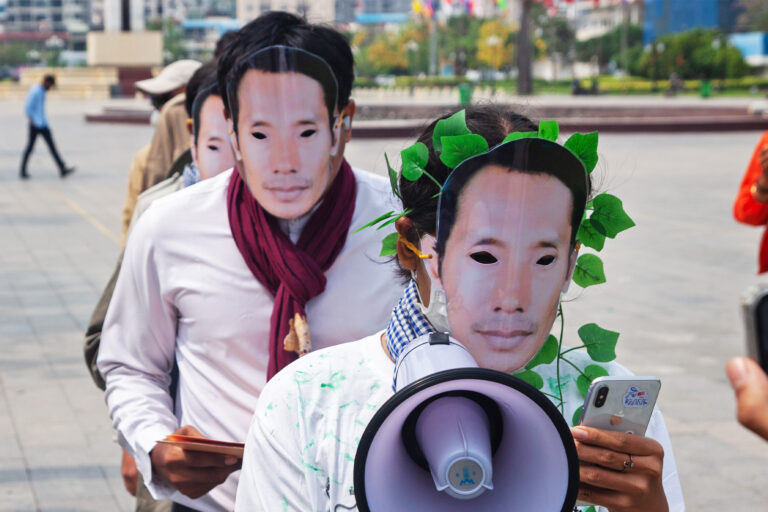 Activists donned masks bearing the face of slain environmentalist Chut Wutty while demonstrating in Phnom Penh.