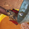 A miner panning for gold in a gold-bearing basin using mercury
