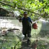 Volunteers clearing plastic trash gathered from river barriers. Image courtesy of Sam Benchegjib.