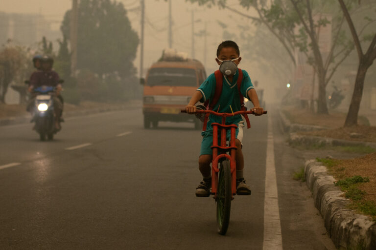 A student goes to school wearing a mask in the haze that blankets the city of Palangka Raya, Central Kalimantan in 2017.